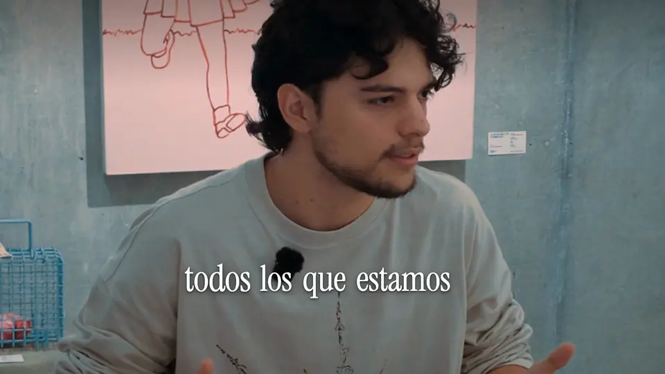 Samu en primer plano en la mesa del cowork, explicando cómo edita sus videos con Claude